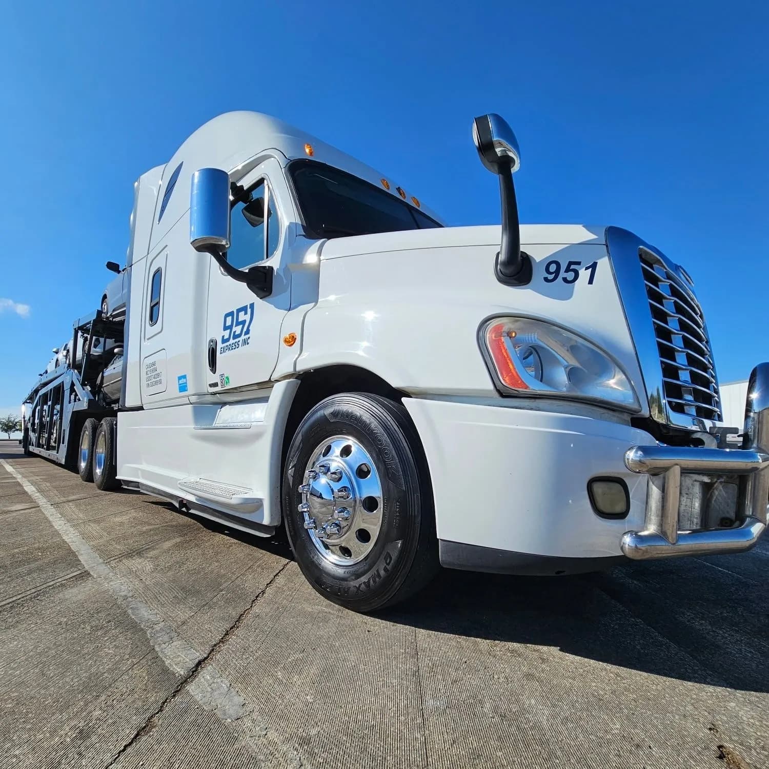 The front of a white 951 Express truck with chrome wheels and bumper.